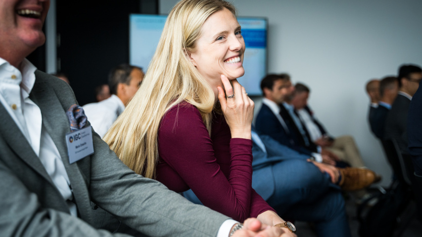 Eine lächelnde Frau sitzt im Publikum.